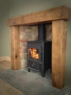 a wood burning stove sitting inside of a brick fireplace