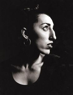 a black and white photo of a woman with earring's looking off to the side