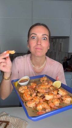 a woman sitting at a table with a tray of food in front of her