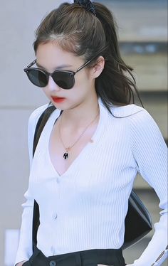 a woman wearing sunglasses and a white shirt