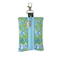 a blue and green bag with a keychain hanging from it's side