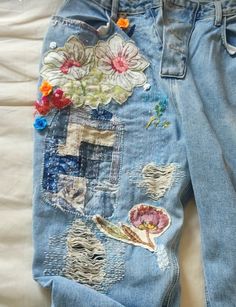 an old pair of jeans with patches and flowers on them