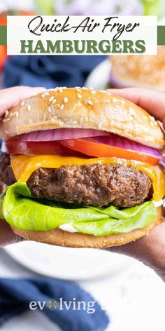 a hand holding a hamburger with lettuce, tomato and onion on it in front of the text quick air fryer hamburgers