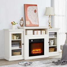 a white entertainment center with a fire place