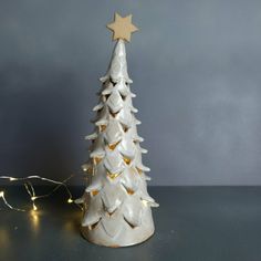 a white ceramic christmas tree with gold stars