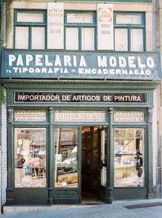 a store front with green trim and windows