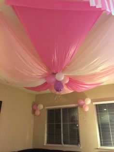 the ceiling is decorated with pink and white balloons