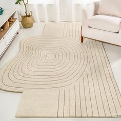 a living room with a white chair and rug