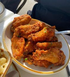 fried food on a white plate with gold trimmings and silverware next to it