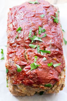 the meatloaf is covered in sauce and garnished with fresh parsley