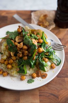 a white plate topped with potatoes and spinach