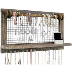 a wooden shelf with several necklaces hanging from it's sides and a phone on the other side