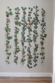 the wall is decorated with green leaves and pink flowers