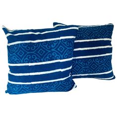 two blue and white pillows on a white background