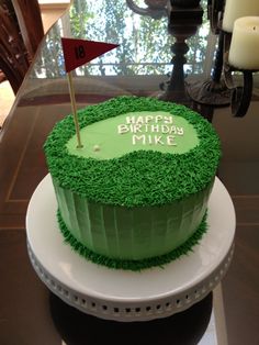 a birthday cake with green frosting and a flag on top