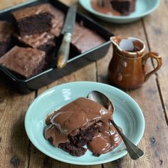 two plates with brownies and chocolate frosting on them, one has a spoon in it