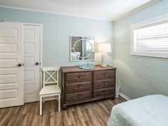 a bedroom with blue walls and wooden floors