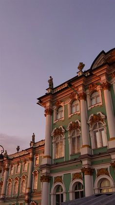 an old building with many windows on the front and side of it at sunset or dawn