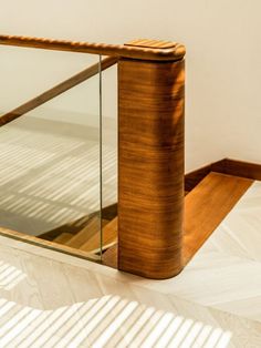 a wooden and glass railing in an empty room