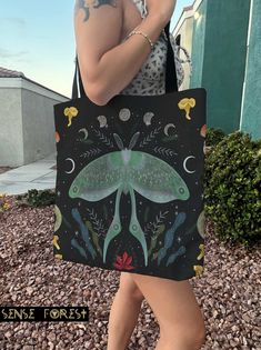 "Luna Moth mushroom Forest Tote Bag, Dark Cottagecore Tarot witch tote, Witchy large Polyester tote bag, boho hippies gift This practical, high-quality Tote Bag is available in three sizes. All over print provides comfort with style at the beach or out in town. Made from reliable materials, lasting for seasons. .: 100% Polyester .: Boxed corners .: Black cotton handles .: Black lining Size: S 13\"x13\" M 16\" x 16\" L. 19\"x19\" Ref:632 Sense Forest would like to provide some clarity regarding the creation of our designs. We take pride in crafting all our designs in our dedicated workshop located in Las Vegas, USA. For some of our products, we handle the printing in-house. However, for larger items that require specialized equipment, we collaborate with production partners both in the Unit Bohemian Tote Canvas Bag As Gift, Bohemian Canvas Shoulder Bag Gift, Bohemian Canvas Shoulder Bag As Gift, Bohemian Shoulder Canvas Bag For Gifts, Bohemian Style Tote Canvas Bag As Gift, Black Bohemian Canvas Bag For Daily Use, Bohemian Canvas Tote Bag As Gift, Bohemian Shoulder Canvas Bag, Whimsical Handmade Bags For Everyday Use