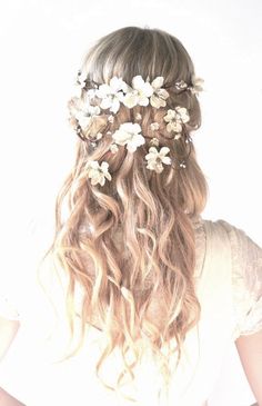 the back of a woman's head with flowers in her hair