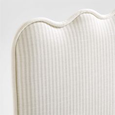 an upholstered headboard with white pinstripe fabric