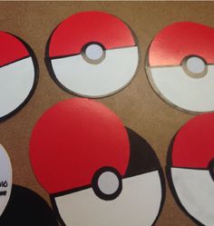 four pokemon poke ball coasters sitting on top of a table next to each other