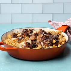 a casserole dish with meat and cheese on it sitting on a blue counter