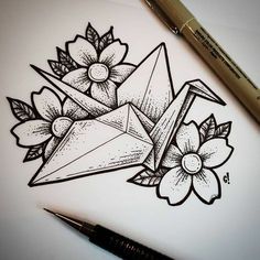 a pencil drawing of an origami with flowers and leaves on paper next to a pen