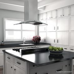 a bowl of green apples sitting on top of a kitchen counter next to a stove