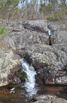 a small waterfall is coming out of the rocks