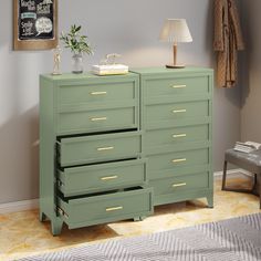 a green dresser with gold handles and drawers in a room next to a gray wall