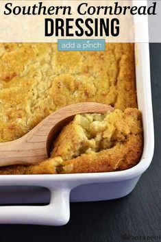 a casserole dish filled with cornbread and topped with a wooden spoon