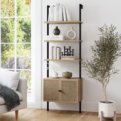 a living room with a white couch and book shelf next to a potted plant