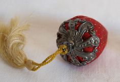 an ornament with a rope attached to it sitting on a white tablecloth