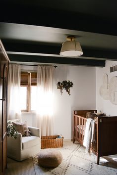 a baby's room with a crib, rocking chair and window