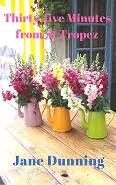 three vases filled with flowers sitting on top of a wooden table next to a window