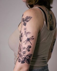 a woman with a dragonfly tattoo on her left arm and right arm behind her back