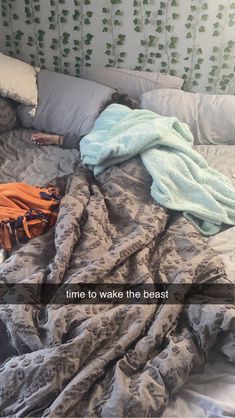 an unmade bed with blankets and pillows on top of it that says time to wake the beast