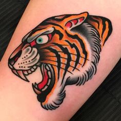 a close up of a tattoo on the arm of a person with a tiger head