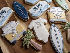 decorated cookies are arranged on a table with surfboards and campervans in the background