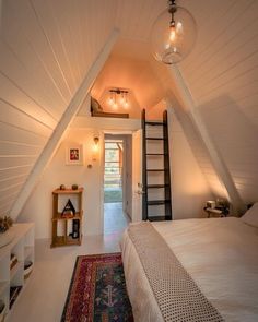 an attic bedroom with a ladder leading up to the second floor and a bed in it