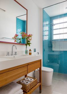 a bathroom with blue tiles and a wooden vanity