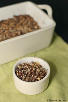 a white bowl filled with granola next to a baking dish