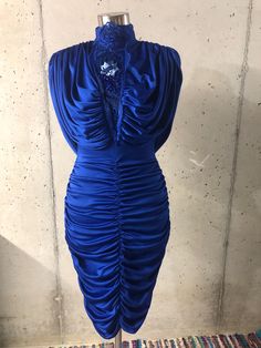 This fabulous dress features a stretchy cobalt blue fabric, a draped open back, and lace beaded neckline. The dress has a run in the back near the center waist and is mostly hidden by the back drape (pictured).   Flat measurements: Bust= 16 - 25 inches Waist= 12 - 20 inches Hips= 17 - 26 inches Neck to bottom hem= 43 inches Neck= 7 inches Tag reads:      Climax for David Howard      Made in California U.S.A. Please note: These are vintage, pre-worn and/or preloved items. I do my best to list any Blue Draped Evening Dress With Ruched Bodice, Stretch Royal Blue Party Dress, Royal Blue Stretch Party Dress, Royal Blue Stretch Dresses For Party, Stretch Ruched Evening Dress For Party, Blue Evening Dress With Ruched Bodice For Party, Blue Party Dress With Ruched Sides, Blue Ruched Draped Evening Dress, Blue Dress With Ruched Sides For Party