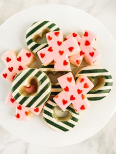 some heart shaped cookies on a plate with candy canes in the shape of hearts