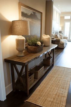 Rustic wooden console table with baskets and a lamp next to a cozy living room. Entryway With Tv, Entry Way Table Decor With Mirror, Rustic Entryway Table Decor, Entryway Ideas Hallway, Front Entry Hallway Ideas, Foyer Table Ideas, Entry Room Decor, Entrance Ideas Entryway, Organized Entryway