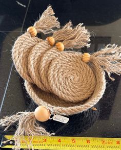 a piece of jute rope with tassels on it and a measuring tape