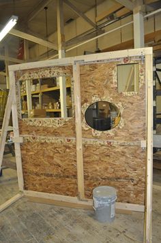 the inside of a building that is being built with wood and plywood panels on the walls