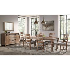 a dining room table and chairs in front of large windows